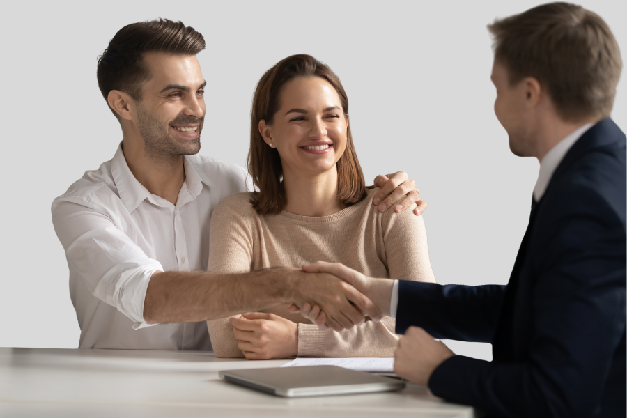 Casal a consolidar crédito, apertando a mão do gestor de crédito.